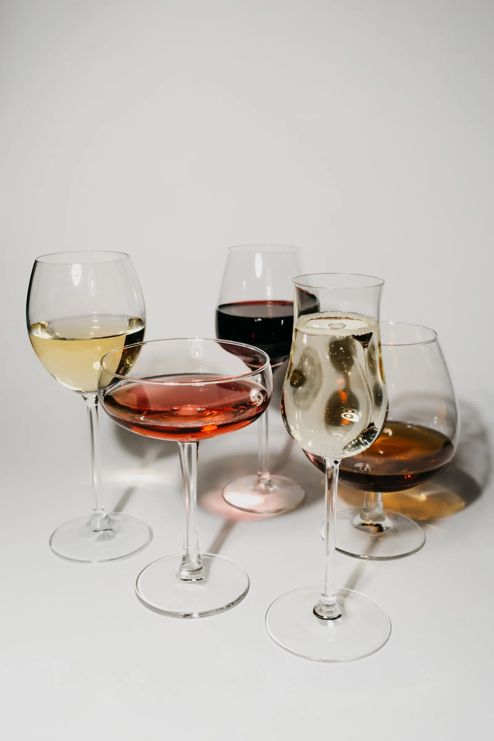 Glazen met witte, rosé en rode wijn op een lichte tafel