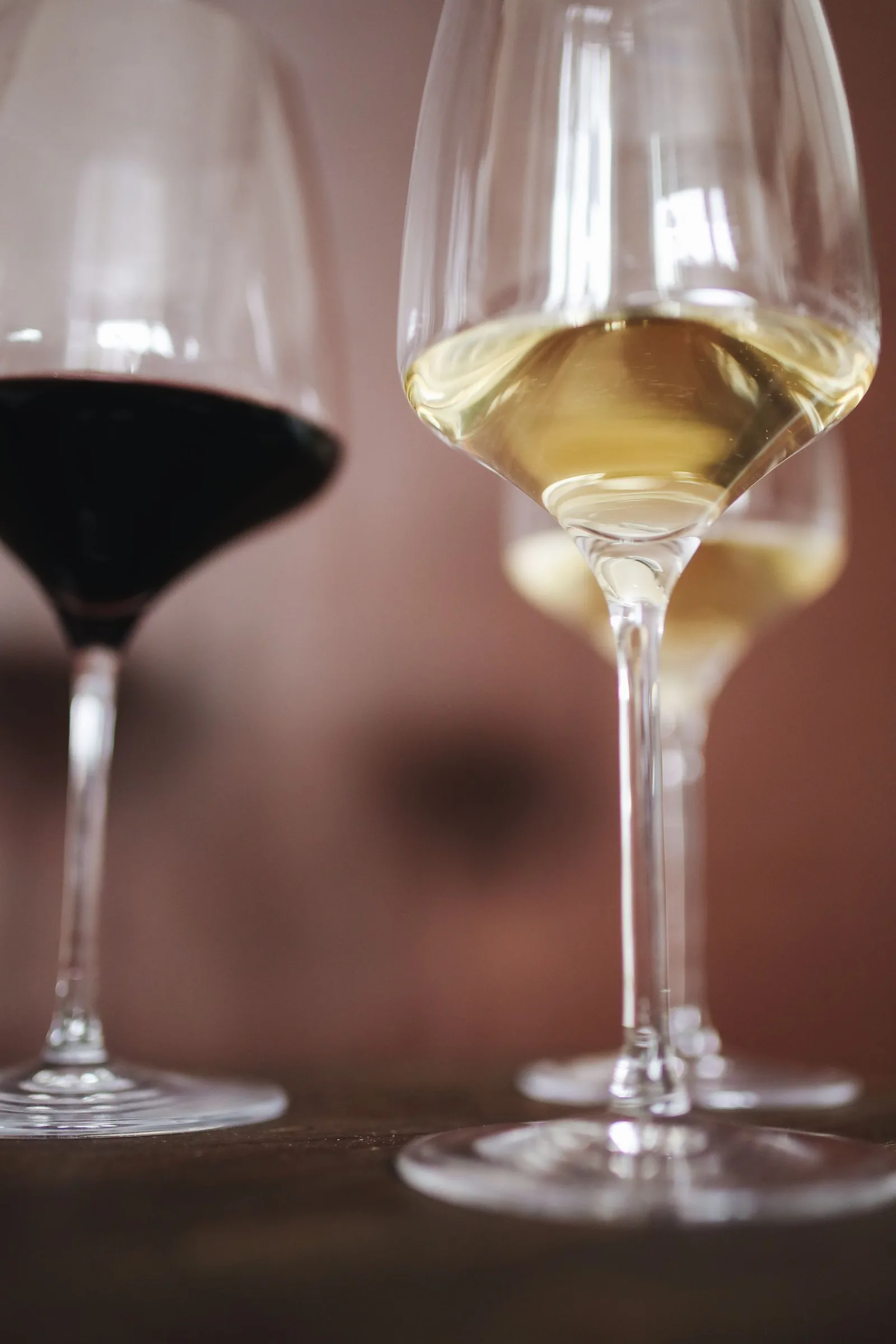 Een glas rode en een glas witte wijn naast elkaar