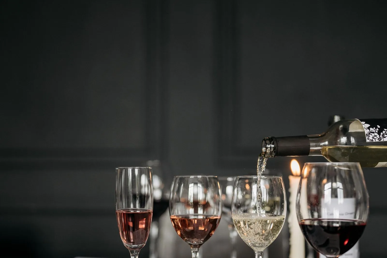 Glazen met witte, rosé en rode wijn naast elkaar op tafel
