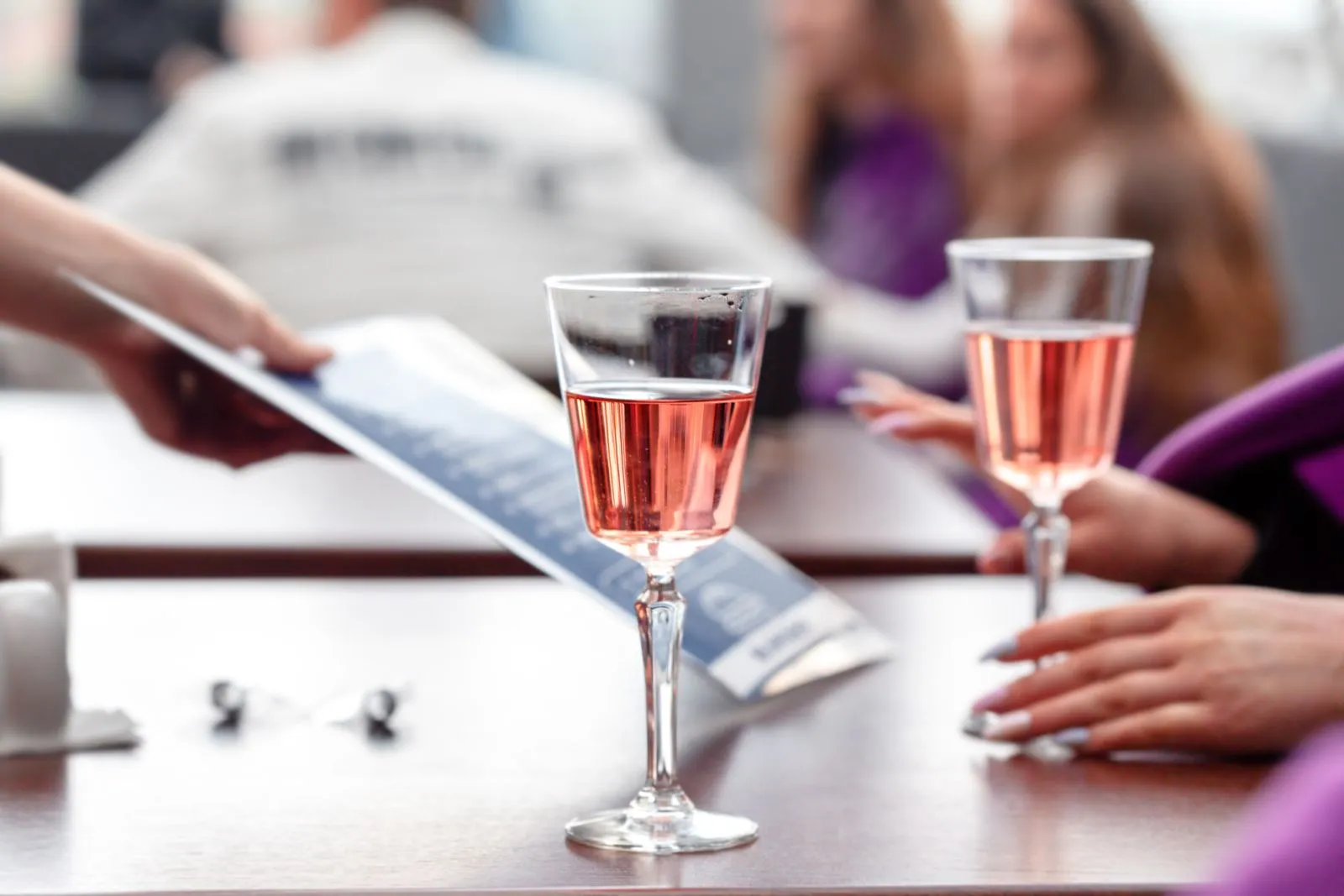 Twee glazen lichtroze wijn op een gedekte tafel