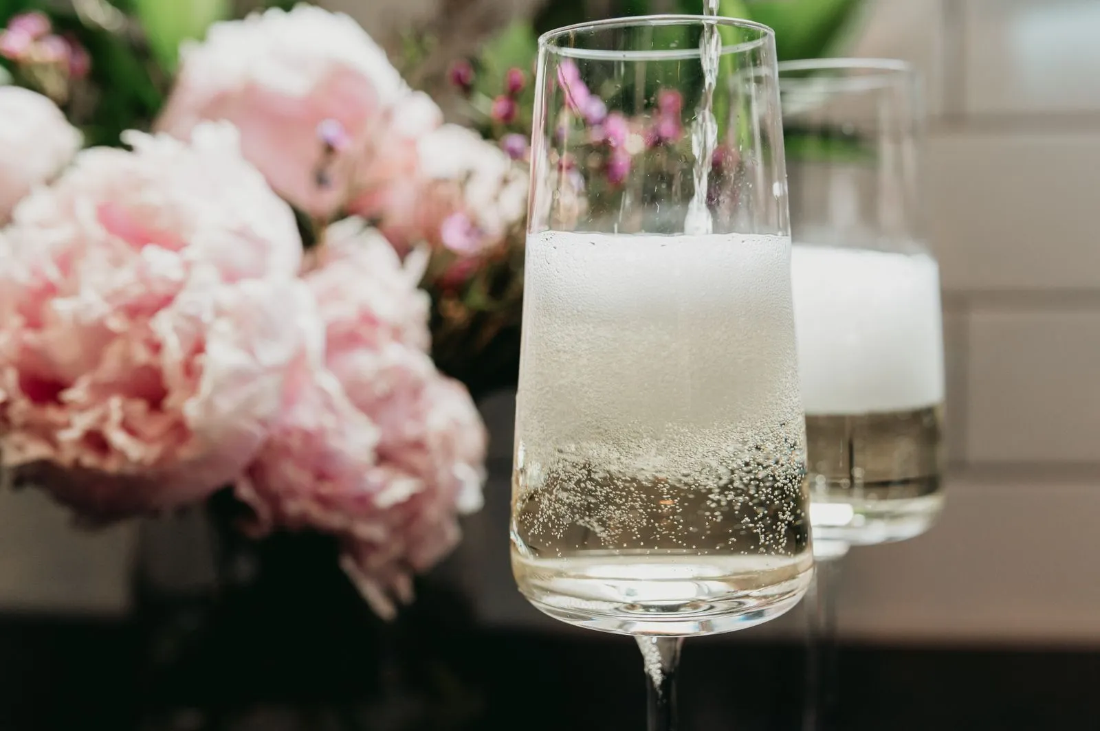 Twee glazen mousserende witte wijn met zichtbare bubbels en schuim